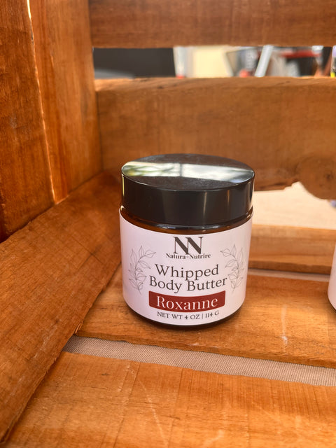 Silky Soft Whipped Body Butter jar in Roxanne scent tucked in a wooden crate corner