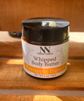 Silky Soft Whipped Body Butter jar in Pineapple Papaya scent on a sunlit wooden surface