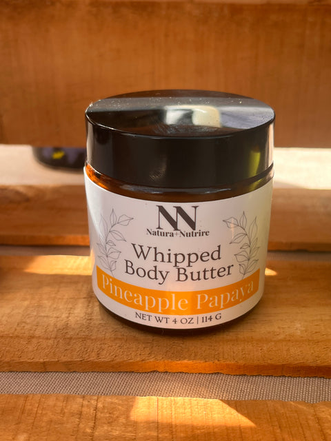 Silky Soft Whipped Body Butter jar in Pineapple Papaya scent on a sunlit wooden surface