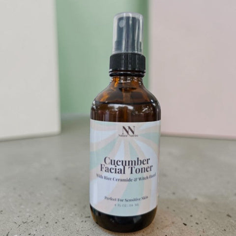 Cucumber Facial Toner with Rice Ceramides bottle standing on a concrete surface against a mint green and pink backdrop