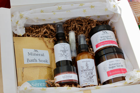 Natura+Nutrire gift box with Whipped Body Butter in Strawberry Coco, Botanical Sugar Scrub, Serenity Magnesium Lotion, Magnesium Spray, Mineral Bath Soak, Rose Renewal Clay Mask, and a lip balm, in white star-patterned tissue paper