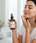Woman applying Hydrating Rice Ceramide Face Lotion to her cheek, holding the bottle in a bathroom setting