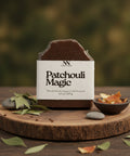 Patchouli Magic Vegan Soap bar on a wooden stand with bay leaves and dried orange peel