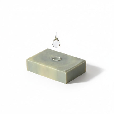 Charcoal & Tea Tree Face Bar Soap single bar with a water droplet falling onto it, on a white background