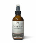 Cedar Rum Magnesium Lotion 4oz spray bottle with green and gray mountain-patterned label on a white background