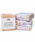 Lavender Dreamin' Handcrafted Vegan Soap bars stacked with pink and lavender striped packaging on a white background