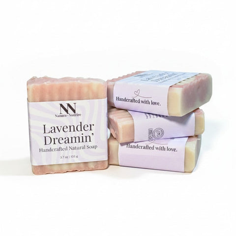 Lavender Dreamin' Handcrafted Vegan Soap bars stacked with pink and lavender striped packaging on a white background