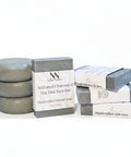 Charcoal & Tea Tree Face Bar Soap round and rectangular bars stacked with their packaging on a white background