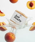 Just Peachy Tallow Soap bar splashing into water surrounded by fresh peach slices