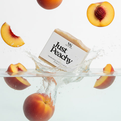 Just Peachy Tallow Soap bar splashing into water surrounded by fresh peach slices
