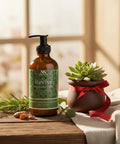 Revive Magnesium Lotion pump bottle on a wooden table with a potted succulent tied with red ribbon, fresh rosemary sprigs, and turmeric root