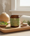 Revive Magnesium Cream jar on a wooden tray with a diffuser, rolled towel, fresh herbs, and spa stones in a softly lit room