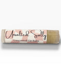 Unsalted Sally Fragrance-Free Olive Oil Lip Balm tube lying on its side on a white background