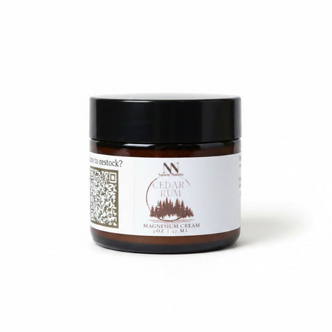 Natura+Nutrire Magnesium Cedar Rum muscle relief cream in a 2oz amber glass jar with a black lid.