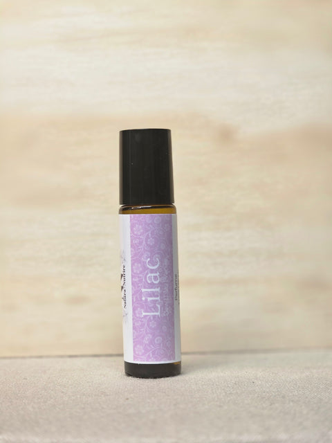Body Oil Perfume Lilac rollerball bottle standing on a light wood surface