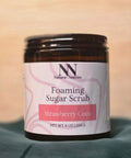 Foaming Sugar Scrub jar in Strawberry Coco scent on a teal fabric background