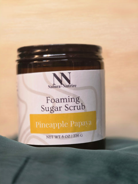 Foaming Sugar Scrub jar in Pineapple Papaya scent on a teal fabric background
