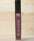 Roxanne Handcrafted Non-Toxic Fragrance rollerball bottle standing on a light wood surface