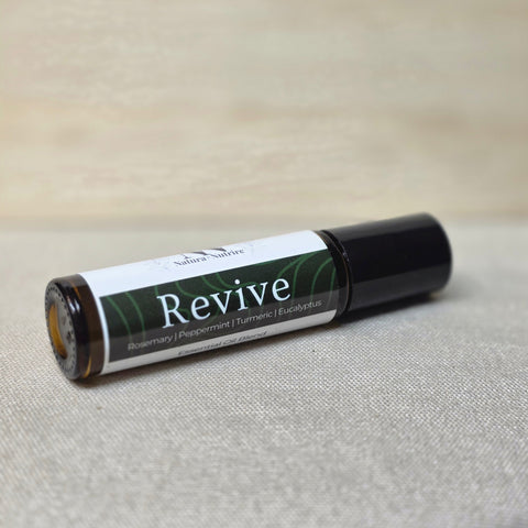 Revive Essential Oil Roller bottle lying on a linen surface