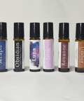 Body Oil Perfume rollerball bottles lineup: Seraph, Obsidian, Luna, Lilac, Roxanne, and Umber, on a white background
