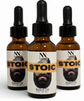 Three bottles of Stoic Beard Oil with droppers on a white background