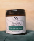 Foaming Sugar Scrub jar in Watermelon Sugar scent on a teal fabric background