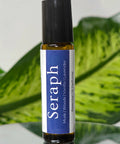 Seraph Natural Botanical Fragrance rollerball bottle with blue label on a reflective surface with green leaves in the background