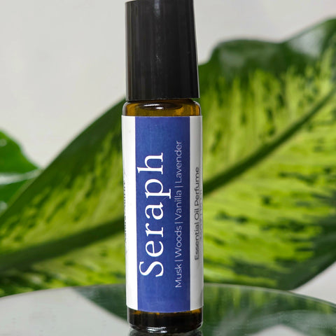 Seraph Natural Botanical Fragrance rollerball bottle with blue label on a reflective surface with green leaves in the background