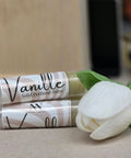 Vanille Vanilla Solid Perfume tubes with a white flower on a beige background