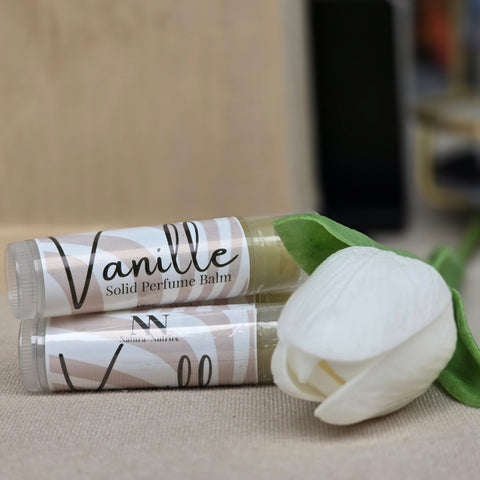 Vanille Vanilla Solid Perfume tubes with a white flower on a beige background